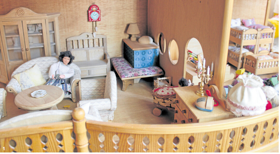 Blick in ein komfortabel eingerichtetes Puppenhaus, mit Kachelofen, bequemen Polstersesseln, Doppelstockbetten und Spielzeug f�r die vielen Puppenkinder.