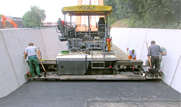 Die Asphalttragschicht wird aus säurefester Asphaltmischung je nach Belastungsklasse mit 10 bis 14 cm auf einem stabilen Untergrund aufgetragen. Damit die Qualität beim Einbau stimmt, sind Lufttemperatur, trockene Witterung, Einbauunterlage und der angelieferte Asphalt wichtig.