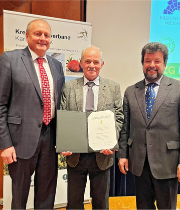 Werner Kunz mit der Goldenen Ähre. LBV-Präsident Joachim Rukwied (l.) und Kreisvorsitzender im Bauernverband Karlsruhe, Helmut Jäger (r.), gratulieren.