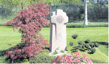 Das Rot des Ahorn-Laubes passt bei diesem Familiengrab sehr gut zum r�tlichen Grabzeichen.