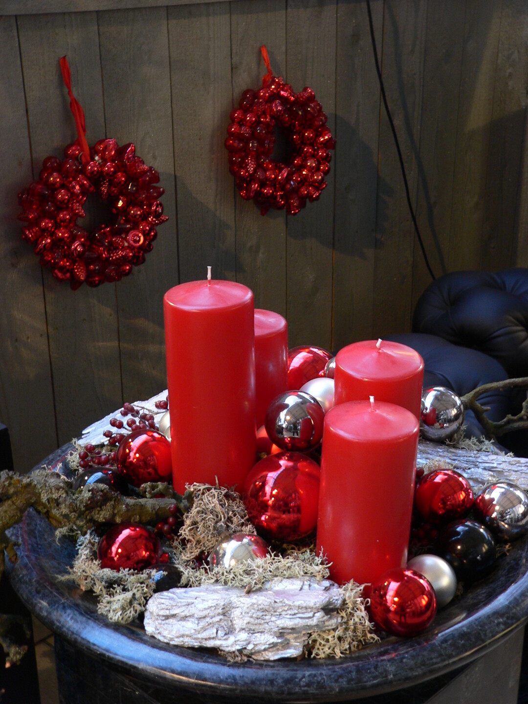 Rote Stumpen-Kerzen sind wahre Klassiker der Adventszeit, die durch silberne und schwarze Kugeln wahren Glamour erhalten. So entsteht ein faszinierendes Spiel aus Tradition und Moderne. 