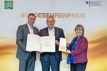 Preisverleihung in Berlin: Ministerialdirigentin Gaby Kirschbaum (rechts) und DLG-Vorstandsmitglied Ulrich Westrup (links) überreichen gemeinsam Urkunde und Medaille auf dem Berliner Milchforum an Martin Boschet von der Hohenloher Molkerei.