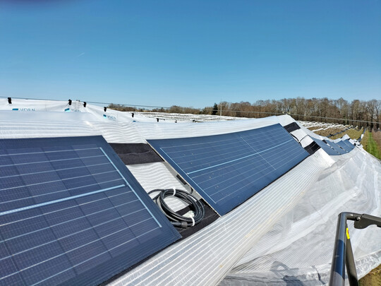 Eigens entwickelte leichte Solarmodule werden auf Streifen einer Schutzfolie angebracht. Hier wurden sie mit zwei Klettstreifen befestigt.