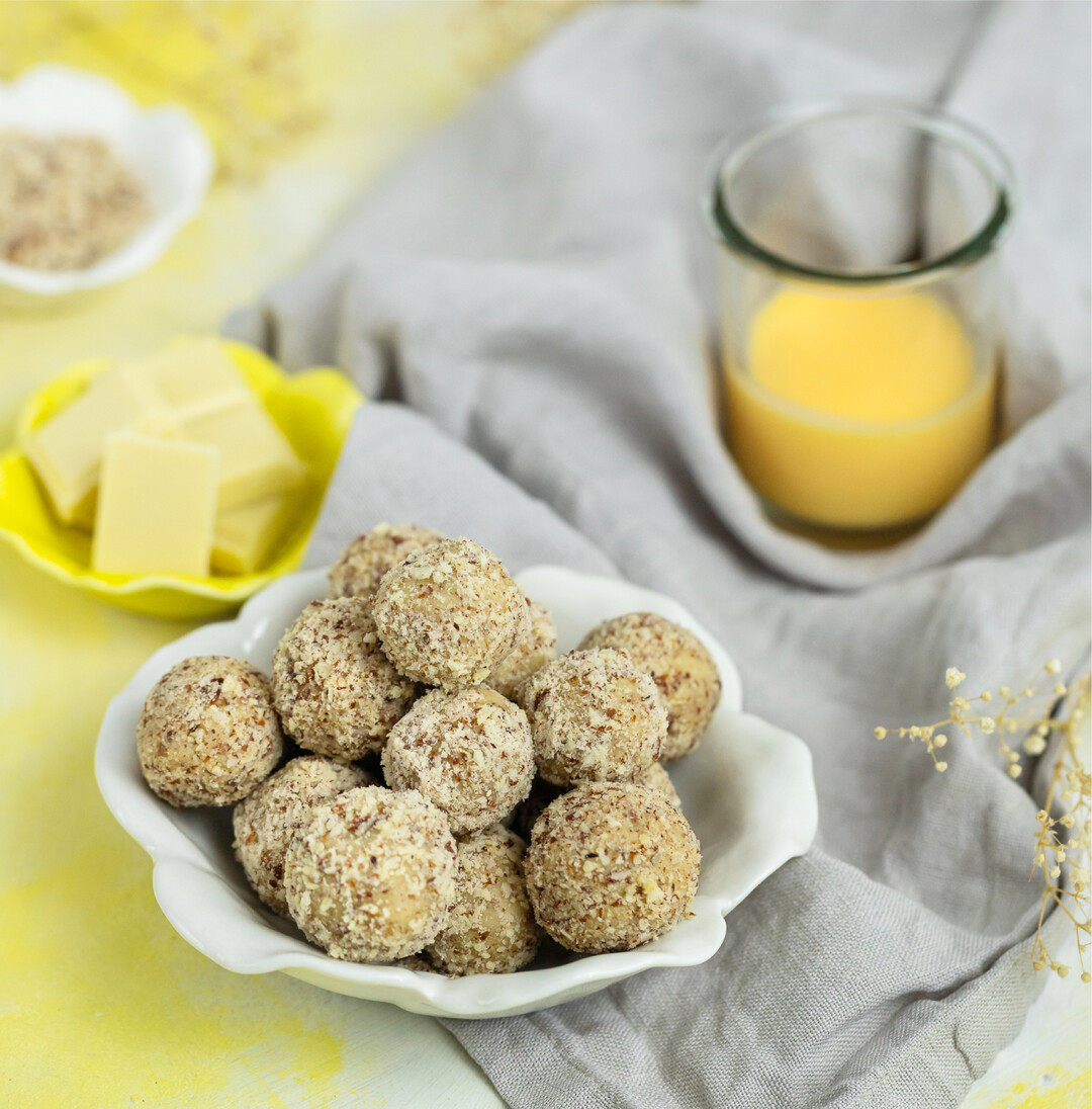 Eierlik�rpralinen  leckeres Ostergeschenk Zutaten 225 g wei�e Schokolade, 140 g Mandeln, 75 ml Eierlik�r und 30 g Butter Zubereitung Mandeln fein hacken. Schokolade grob hacken. Einen Topf mit Wasser f�rs Wasserbad aufsetzen. Gehackte Schokolade in eine Metallsch�ssel f�llen und �ber dem Wasserbad schmelzen lassen. 110 g der Mandeln, Butter und Eierlik�r zu der geschmolzenen Schokolade geben. Verr�hren bis eine gleichm��ige Masse entsteht. F�r 60 Minuten in den K�hlschrank stellen. Je l�nger, desto h�rter wird die Masse. Einen Teller mit den restlichen gemahlenen Mandeln bedecken. Einen Teel�ffel der Pralinenmasse abnehmen, in der Hand zu einer Kugel formen und in den gemahlenen Mandeln w�lzen. So verfahren, bis alle Eierlik�r-Pralinen geformt und gew�lzt sind. Isabelle Arndt