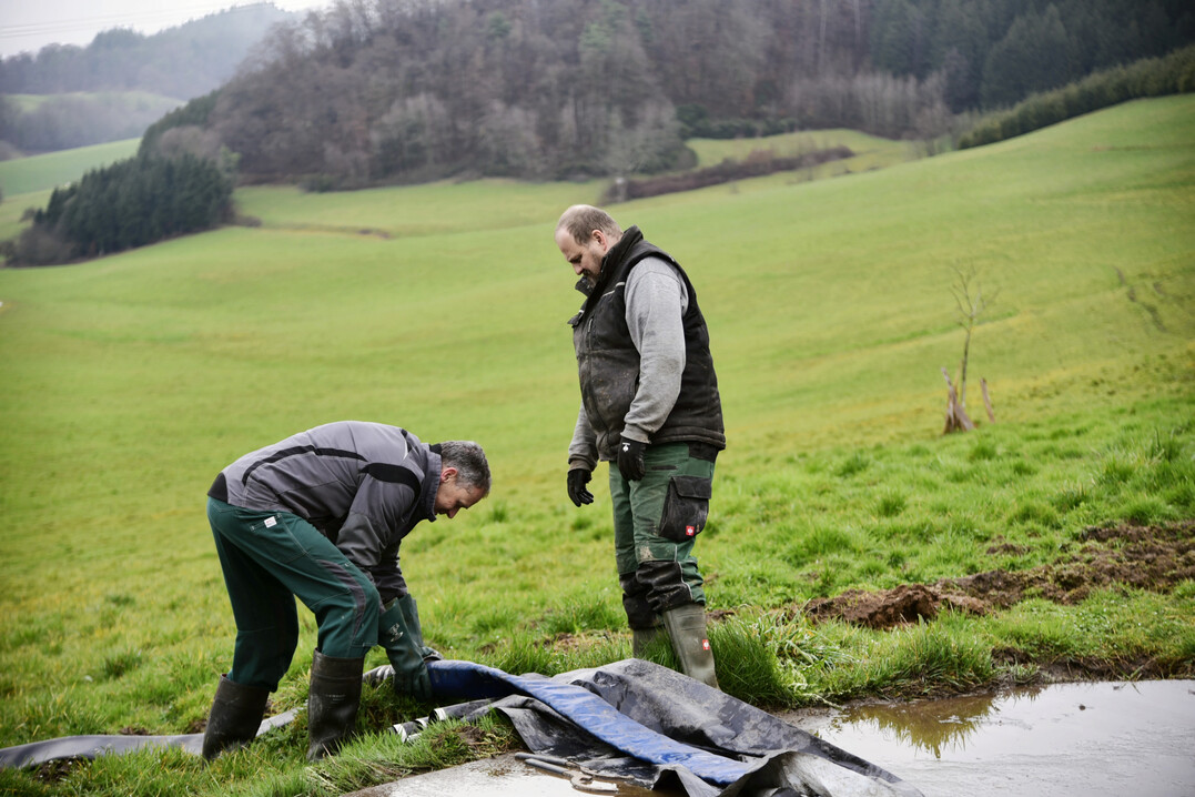 Am Schlauch entsteht Reibung durch die Vibration der Exzenterpumpe am Übergang vom Deckel der Güllegrube zum Grünland. Benedikt Himmelsbach schützt diesen durch das Unterlegen einer Plane.