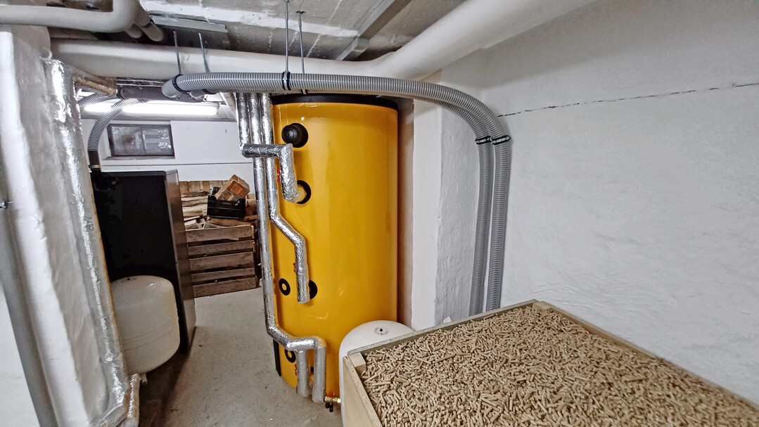 �ber einen Pufferspeicher lassen sich verschiedene Heizquellen zusammenf�hren. Rechts im Bild, ein offenes Pelletlager. Kessel, Brennstofflager und Pufferspeicher sind f�rderf�hig.�