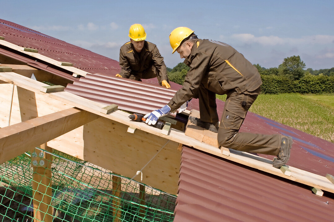 Vorbildliche Arbeitsweise: Es werden Laubohlen verwendet und unter der Dachhaut sowie an den Absturzkanten sind Auffangnetze gespannt. Bohlen und Netze sind ebenso bei Reparaturarbeiten auf alten D�chern zu verwenden.