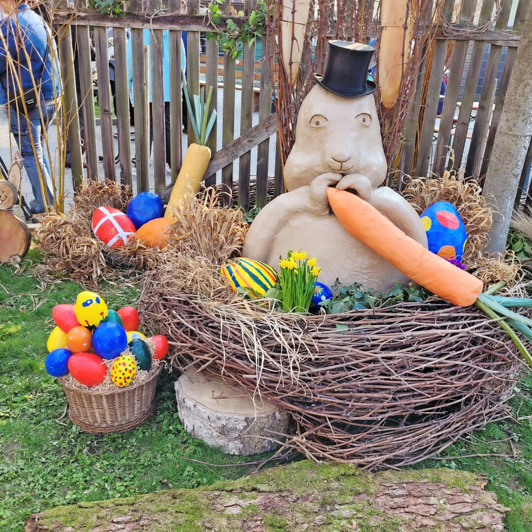 Der Osterhase mit Zylinder freut sich auf die Karotte.