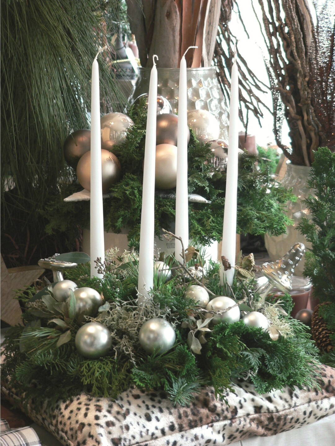 Eine Alternative zum klassischen Adventskranz: Elegante Leuchterkerzen mit dem RAL-G�tezeichen werden mit weihnachtlichen Accessoires auf einem Tannenkranz platziert. Bei diesem Arrangement unbedingt f�r Standfestigkeit sorgen und zwischen Kranz und Kissen aus Sicherheitsgr�nden eine Metallunterlage legen. Au�erdem: Kerzen nie unbeaufsichtigt brennen lassen. 