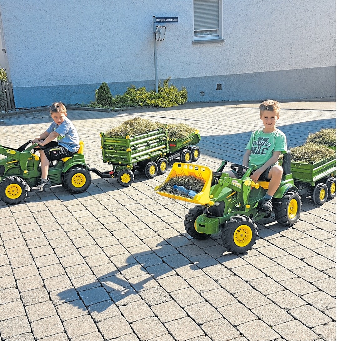 Zwei flei�ige Helfer, die beiden siebenj�hrigen Freunde Leon (links) und Lukas, fahren in Sontheim ein paar Ladungen Heu zum benachbarten Bauern, um es an die K�he zu verf�ttern. Damit sie unterwegs gut bei Kr�ften bleiben, darf die Wasserreserve nicht fehlen.