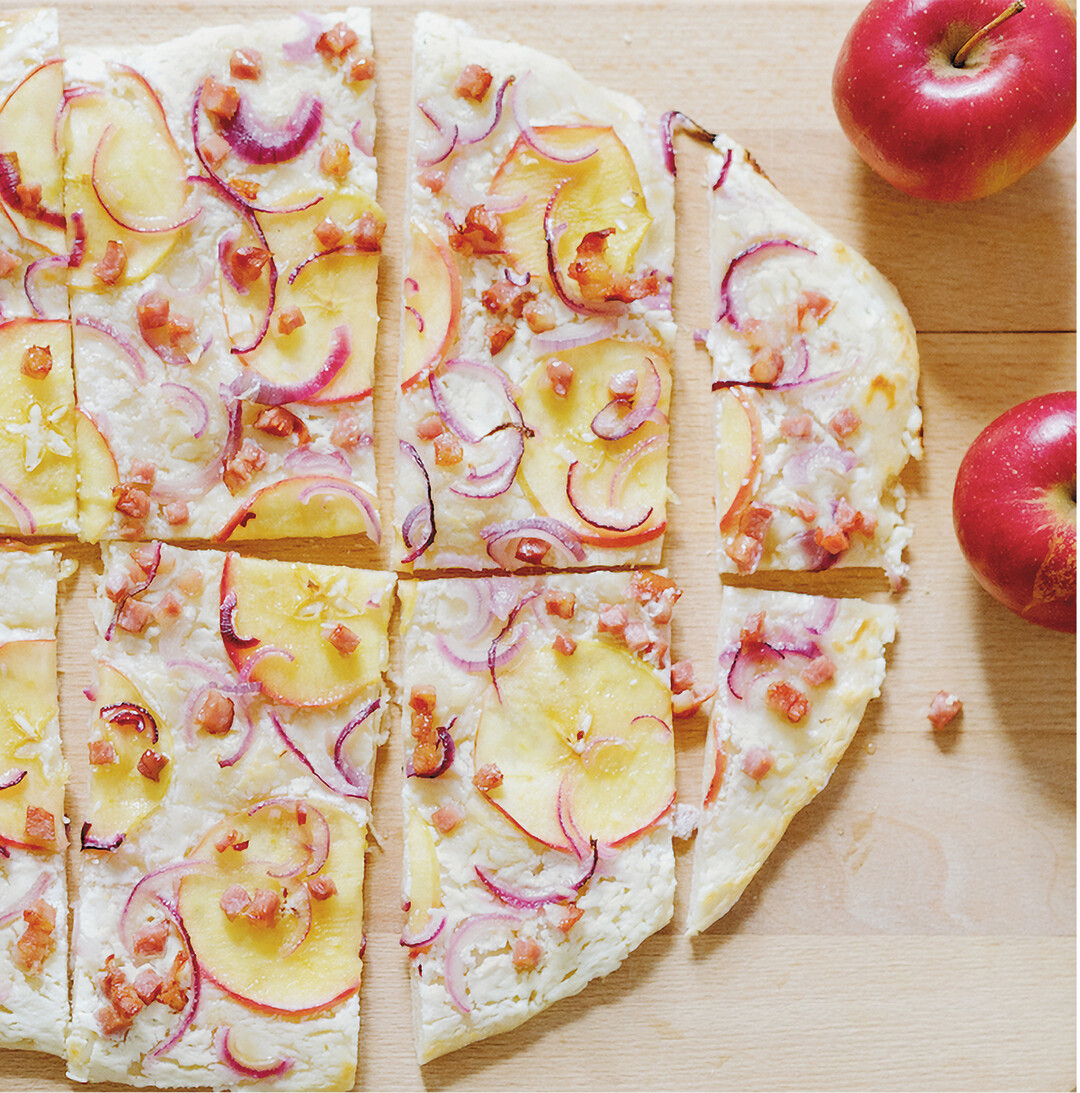 Dieser leckere Apfelflammkuchen ist schnell zubereitet. Der Boden aus d�nnem Hefeteig wird mit 200 Gramm Schmand bestrichen, mit Speckw�rfeln, d�nn gehobelten Apfelscheiben und Zwiebelringen belegt, mit Salz und Pfeffer etwas gew�rzt. Bei 250 Grad im unteren Ofendrittel knapp 15 Minuten backen. Zum Schluss zwei Essl�ffel fl�ssigen Honig �ber den Flammkuchen tr�ufeln.