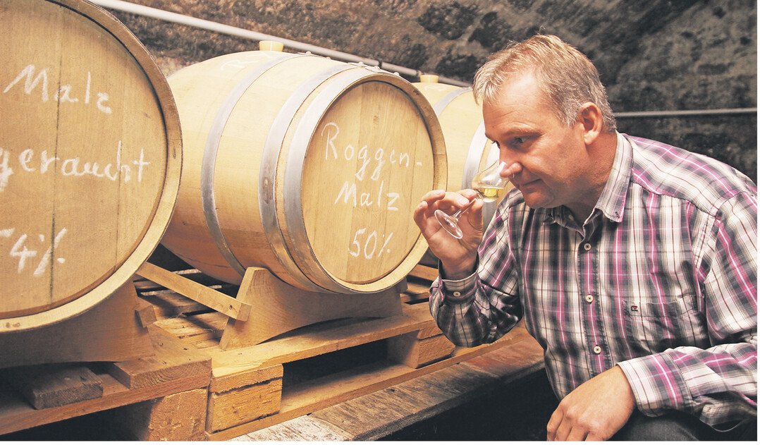 Jungwhiskyprobe � Karl M�ller schnuppert an einem torfgerauchten Gerstenbrand aus eigener Herstellung. Die Getreidebr�nde reifen seit knapp drei Jahren im Gew�lbekeller.