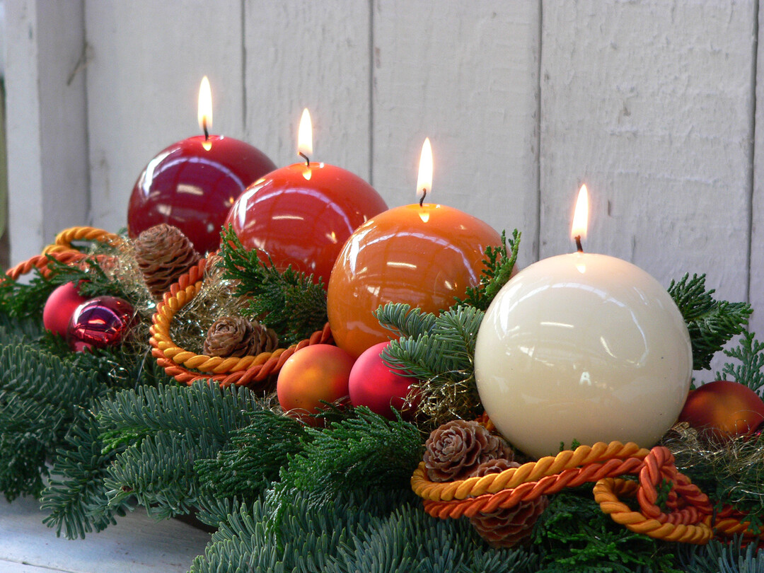  Vier gl�nzende Kugel-Kerzen in unterschiedlichen Braun- und Rotnuancen werden mit weihnachtlichen Accessoires zu einem Adventsgesteck arrangiert. 