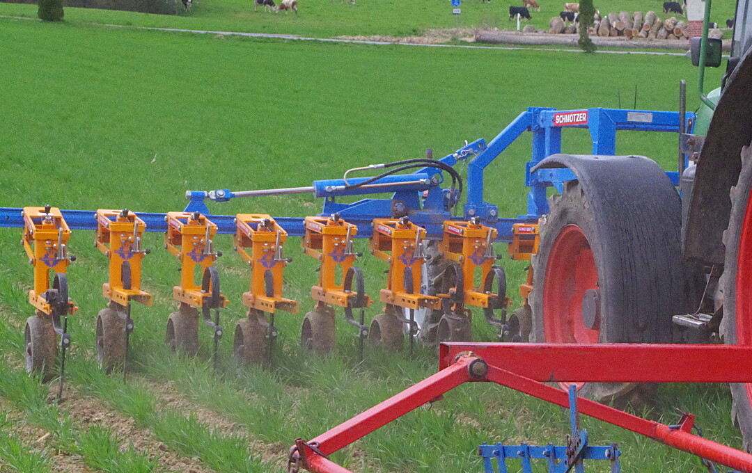 Hacke Schmotzer mit Kombi-Parallelogramm: Die kameragesteuerte Hacke kann laut Hersteller im Front- oder Heckanbau gefahren werden, wobei die Parallelogramme immer ziehend angeordnet sind. Im Einsatz war die betriebseigene Hacke im Frontanbau. Au�erdem wurden noch zwei weitere Hackger�te von Schmotzer ausgestellt. Diese waren mit einem kleinen Kombiparallelogramm und Handsteuerung sowie Kamera ausgestattet. Bei neusten Kamerasystemen setzt der Hersteller unter anderem auf die Erkennung von Blattform und Farbe, was die Sicherheit bei der Erkennung von Kulturen verbessern soll.  