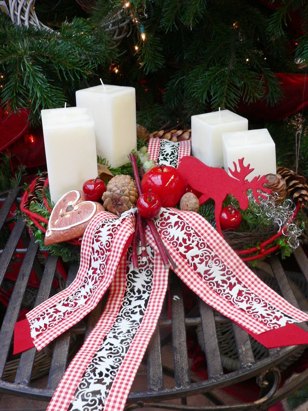 Wei�e Quader-Kerzen in RAL-Qualit�t zaubern in Kombination mit weihnachtlichen Accessoires in rot-wei� einen zauberhaften Adventskranz. Das aufwendig gestaltete Band  in Scherenschnittoptik, sowie der kleine Elch aus Filz verleihen dem Arrangement einen Hauch von schwedischer Weihnachtsromantik. 
