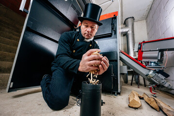 Ein Schornsteinfeger kontrolliert die G�te von Holzhackschnitzeln.