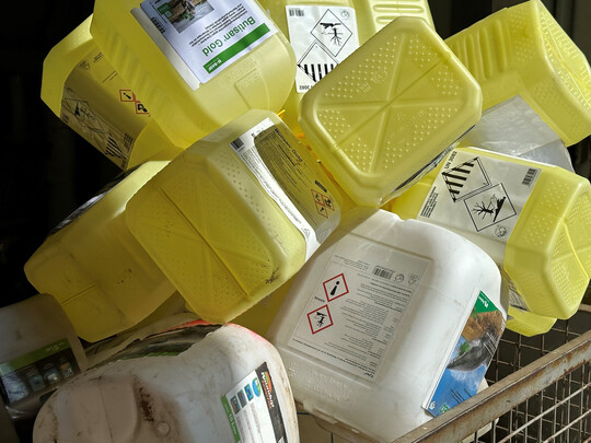 Leere Pflanzenschutzmittelkanister stehen zur Rückgabe.