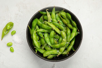 Gekochte Edamame, mit etwas Salz bestreut, sind ein gesunder Snack.