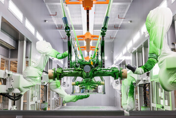 Voll automatisiert: Blick in die Lackierkabine in Mannheim, in der Roboterarme die Farbe auf die Bauteile auftragen. 