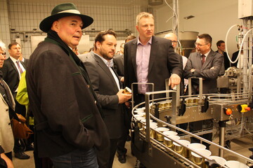 Vor dem Laufband der Wurstdosen mit wiederverschließbarem Schnappverschluss, v. l.: Rudolf Bühler, Agrarminister Alexander Bonde und der Technische Leiter Steffen Noller.