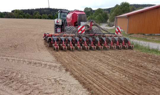 Drillmaschine mit 6 m Arbeitsbreite. Die Maschine ist modifiziert zur Zwischenreihensaat und zur Fl�ssigimpfung des Saatgutes direkt bei der Saat. Statt Scheiben schneiden G�nsefu�schare vor der Saat den Boden auf H�he des Saatgutes ab, um Beikraut zu unterdr�cken.
