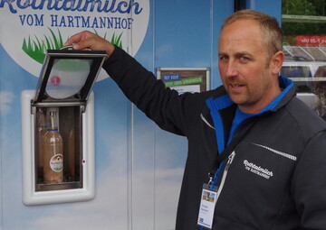 Milch per Knopfdruck: Christian Hartmann, Hartmannhof, erkl�rt die funktionsweise des Milchautomaten. Hier gibt es 24 Stunden frische Vollmilch. Am Automaten kann man Flaschen kaufen oder eigene, saubere Flaschen zum Bef�llen mitbringen. 