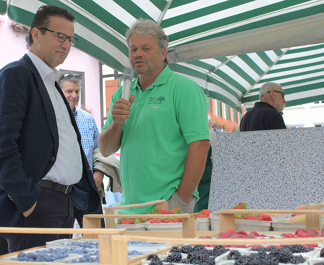 Am Stand des Bauernmarktes Ravensburg informiert sich der Minister bei Thomas Heilig, im Vorstand der Bauernmarkthalle, �ber Obst vom Bodensee.