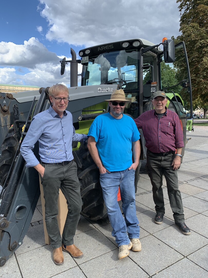 v.l. Marco Eberle, Hauptgeschäftsführer im Landesbauernverband in Baden-Württemberg, Dr. Jochen Brust, Kreisvorsitzender Bauernverband Stuttgart e. V und als Axel Brodbeck mit seinem Traktor, werben auf dem Stuttgarter Schlossplatz für Unterschriften zum Volksantrag.