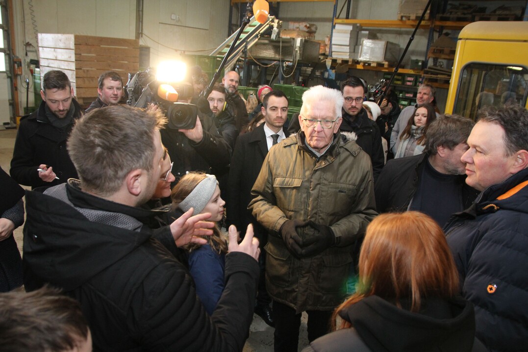 Umringt von Familie Grieshaber will Winfried Kretschmann wissen, wieviele Leute einschließlich Mitarbeiter vom Biohof Grieshaber & Schmid leben.