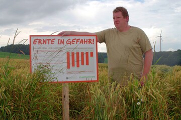Ein Landwirt neben seinem Schild zum Pflanzenschutz, 2016.