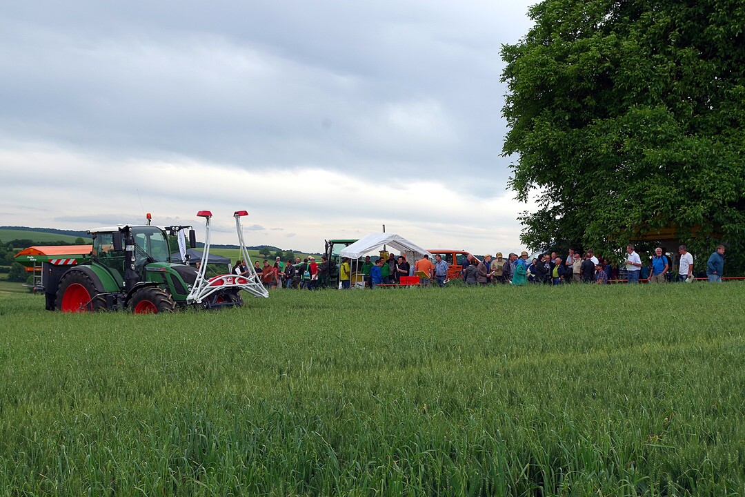 Bei einem Festzelt fanden sich die rund 120 Teilnehmer zum Beginn des Getreidetags am Zentralen Versuchsfeld ein. Im Vordergrund steht ein Traktor mit D�ngerstreuer und Pflanzensensor.
