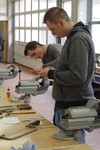 Zwei Auszubildende an der Werkbank. Die Herstellung eines Flaschenöffners aus einer Schraube und einer Mutter war Teil der Aufgaben.