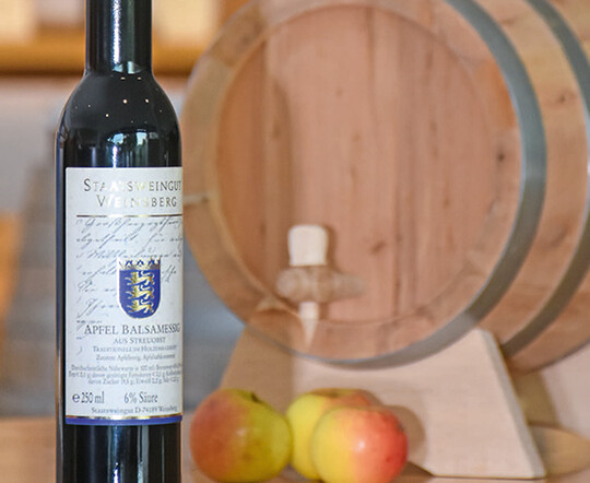 Der neue Balsamessig vor einem Fass aus Wacholderholz
im Verkaufsraum des Staatsweingutes Weinsberg.