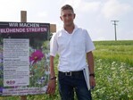 Alexander Kern erklärt im Blühstreifen bei Diedelsheim den Pflanzenmix.