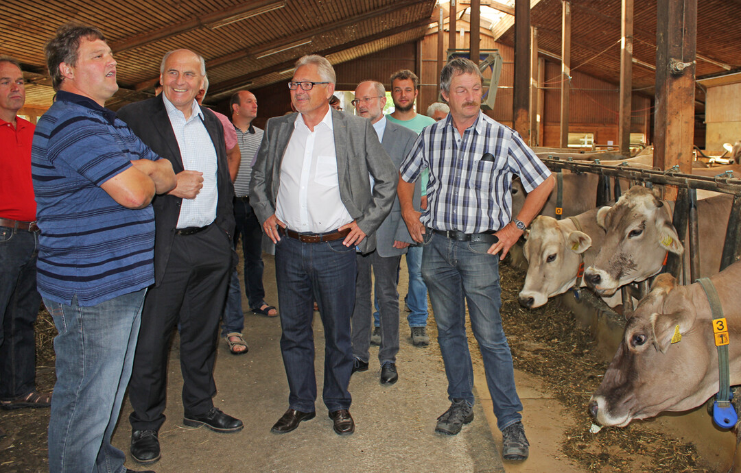Martin Bosch (v.l.n.r.) erläutert den Gästen beim Rundgang, wie seine Kühe gehalten, gefüttert und gemolken werden. Im Bild Waldemar Westermayer und Lothar Riebsamen, beide MdB CDU, und Dieter Mainberger, KBV-Tettnang.