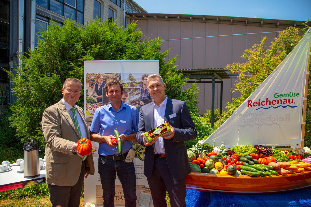 Minister Peter Hauk (l.) und Genossenschafts-Geschäftsführer Johannes Bliestle (r.) nehmen einen der örtlichen Gärtner in ihre Mitte.