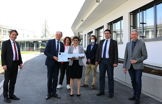 Übergabe: Hermann Zettler vom Landesbetrieb Vermögen und Bau (2. v. l.) übergibt zusammen mit Staatssekretärin Sabine Kurtz (Mitte) den Schlüssel für die neuen Lehr- und Seminarräume, für die das Land 4,4 Millionen Euro investiert hat, an Michael Asse, Direktor im Landwirtschaftlichen Zentrum in Aulendorf (LAZBW) und dessen Stellvertreter in Wangen im Allgäu, Dr. Erwin Kitzelmann (r.). Über die neuen Räume freuen sich der Wangener OB Michael Lang (l.) sowie Petra Krebs (Grüne) und Mathias Rege, Grath Architekten Ravensburg (Reihe hinten).