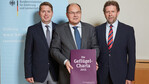 Bundeslandwirtschaftsminister Christian Schmidt (M.) nimmt die Charta von den ZDG-Vizepräsidenten Thomas Storck (l.) und Rainer Wendt entgegen.