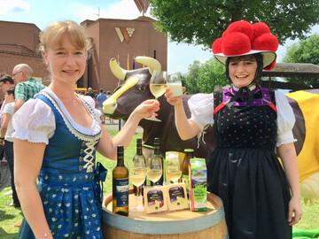 Ein Muuh und ein zum Wohl - Ehemalige Badische Weink�nigin Isabella Vetter und Schwarzwaldmilch-Mitarbeiterin Jasmin M�bius in Schwarzwald-Tracht sto�en vor Sonnenwinzer-Kuh und der Belegschaft der Schwarzwaldmilch und dem Badischen Winzerkeller auf Besuch in Breisach an.