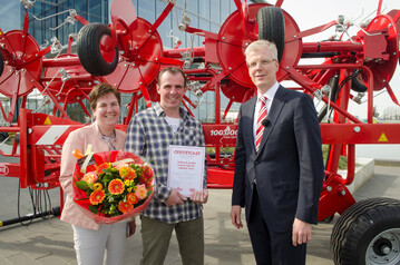 Firmenchef Alexander van der Lely (r.) �ber gibt den Jubil�ums-Schwader an die Familie van der Schriek aus Den Hout