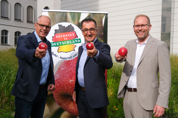 J�rg Hilbers (l.), Gesch�ftsf�hrer Fachgruppe Obstbau, Cem �zdemir, Bundesminister f�r Ern�hrung und Landwirtschaft, Dr. Christian Weseloh (r.), Gesch�ftsf�hrer Bundesvereinigung der Erzeugerorganisationen Obst und Gem�se werben f�r heimische �pfel.
